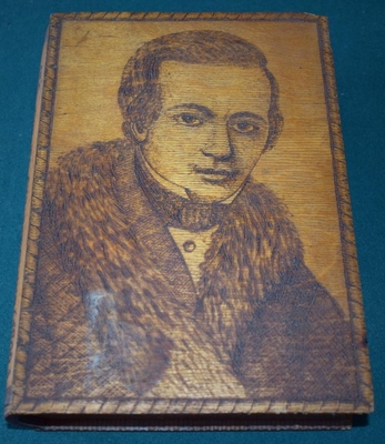 Шкатулка деревянная, сделанная в виде книги с выжженным портретом Кольцова, текстом стихотворения «Разговор на Воронежском кладбище» и отрывка из стихотворения «Урожай».