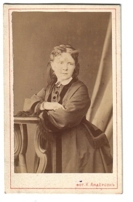 Фотография. Тимешовы. Женщина, стоит облокотившись на  столик.