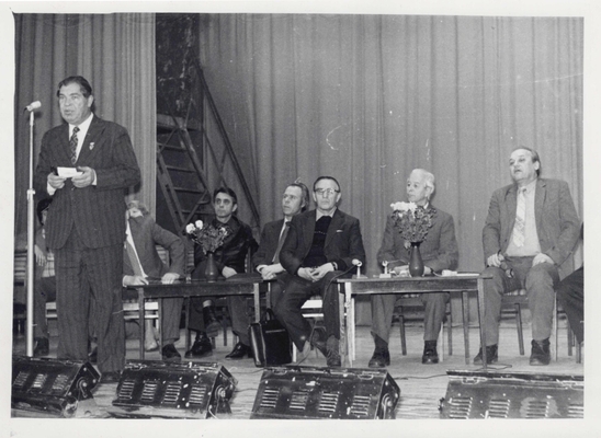 Фотография: Встреча московских писателей со студентами и преподавателями ВГУ. 80-е гг. Выступает Касаткин П. За столиками сидят: Старшинов Н.К., преподаватель ВГУ Абрамов А.М., ректор ВГУ Проскурин П.Л.